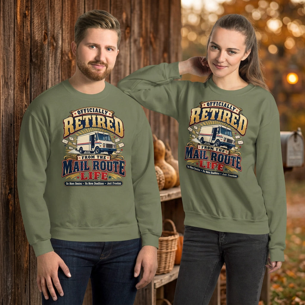 A man and a woman modeling matching sage green crewneck sweatshirts with a vintage-style 'Officially Retired From the Mail Route Life' truck graphic on the chest, set against a plain white background.