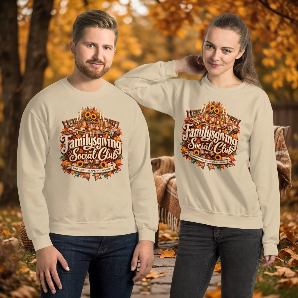 A man and a woman modeling matching beige crewneck sweatshirts with a large autumn-themed graphic on the chest that reads 'Family Giving Social Club' surrounded by fall leaves, pumpkins, and sunflowers.